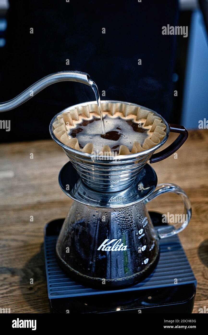 Gran Bretagna / Inghilterra / Londra /stile caffè /Barista utilizzo del contagocce Kalita Wave presso Origin Coffee Roasters a Londra . Foto Stock