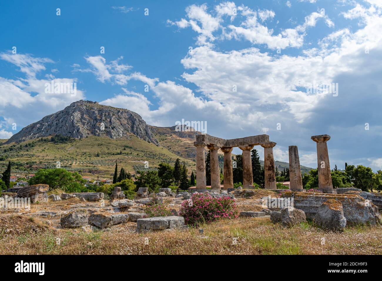 Tempio di Apollo a Corinto antico con il castello di Acrocorinto a. lo sfondo Foto Stock
