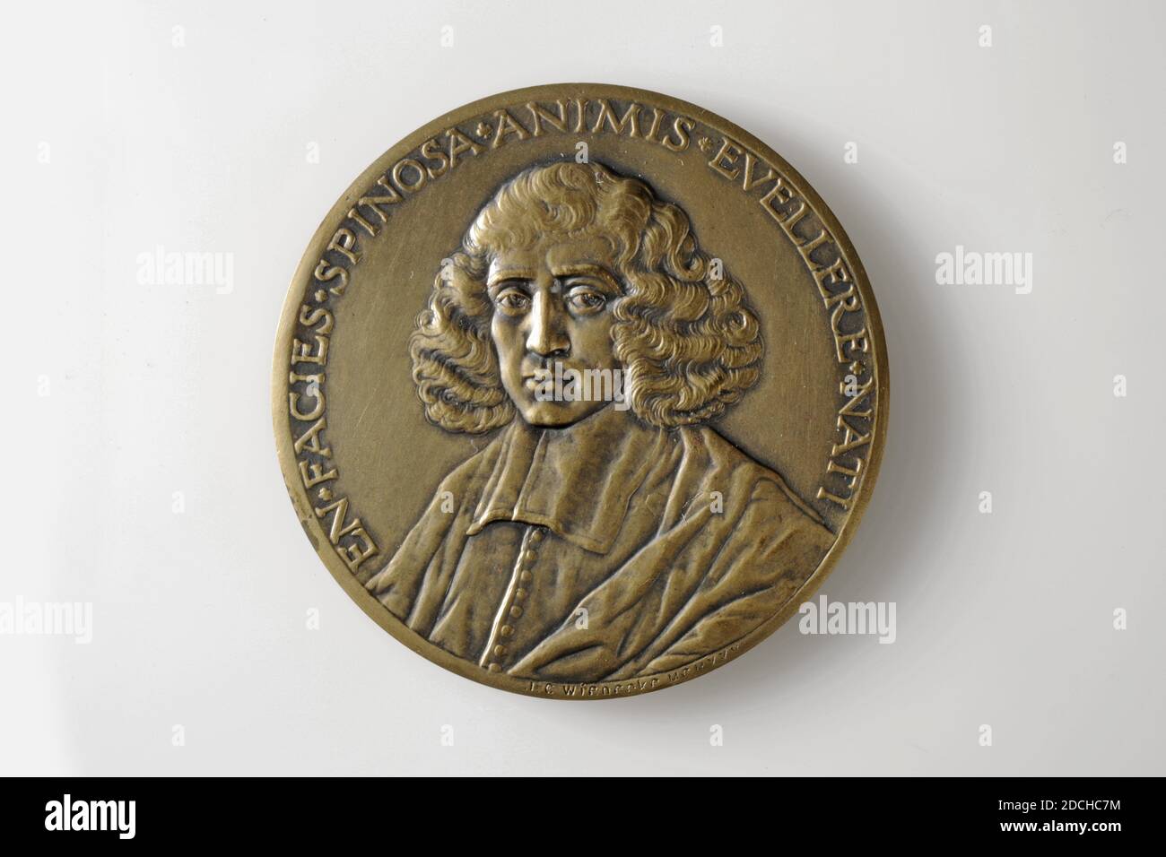 Gettone commemorativo, Johannes Cornelis Wienecke, 1927, coniato, Generale: 6.5 x 0.3cm (65 x 3mm), peso: 89.7g, casa, ritratto dell'uomo, busto, Medaglia commemorante il 350° anniversario della morte di Spinoza nel 1927. La parte anteriore presenta un busto di Spinoza angolato a sinistra di tre quarti. Spinoza ha lunghi capelli ricci ed è vestita in una toga. Intorno alla performance la didascalia: EN.FACIES.SPINOSA.ANIMIS.EVELLERE.NATI. Contrassegnato in basso a destra. Sul retro si trova la casa di Spinoza con i raggi del sole alle sue spalle e le nuvole sopra di essa. SOTTO L'ISCRIZIONE: DOMUS.SPINOZANA RHENOBVRGI BENE.AGERE.ET LAETARI ETH.IV.PROP.LXXIII. Foto Stock