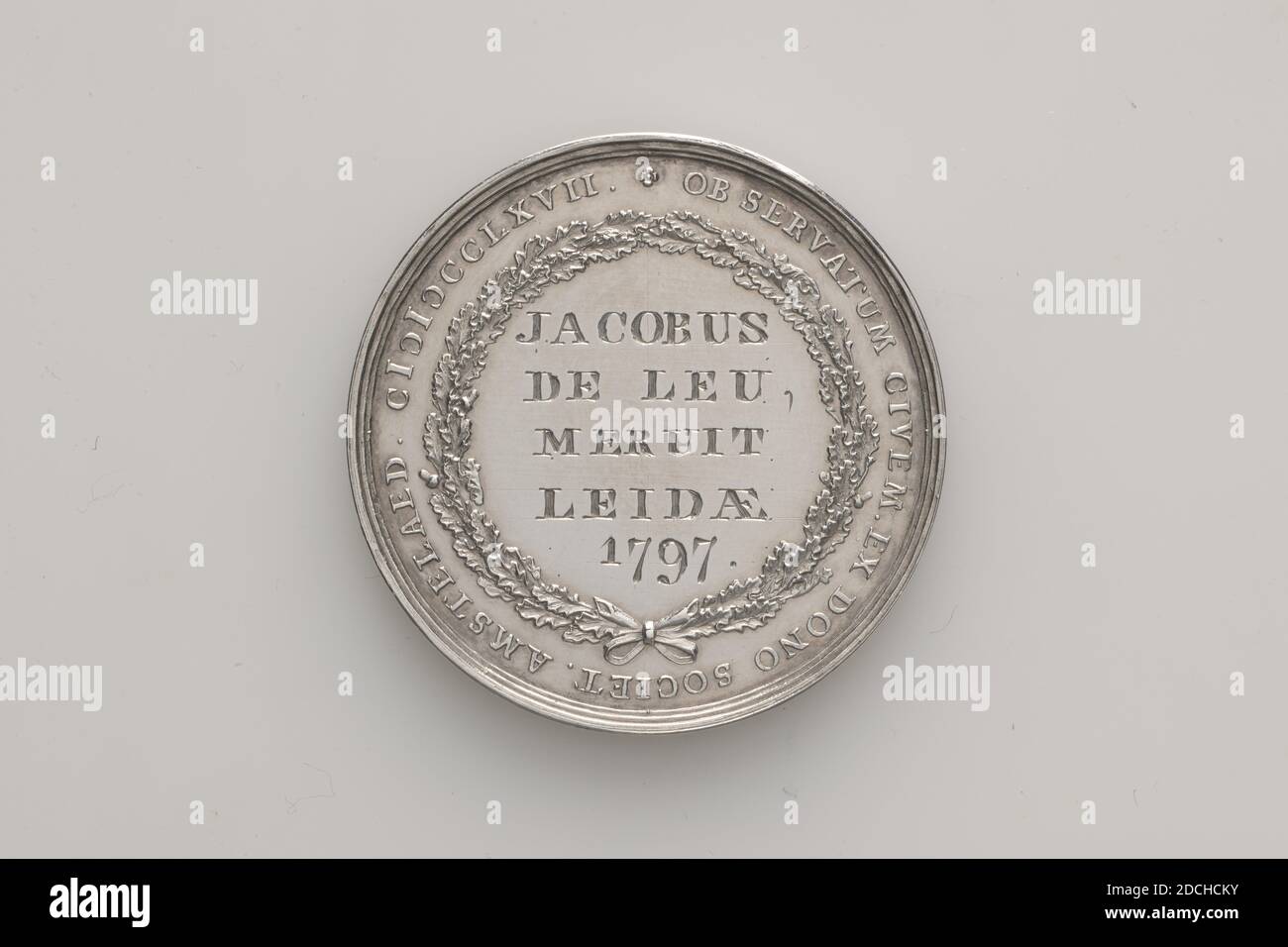 Medal, Johan George Holtzhey, 1797, Generale: 3.5 x 0.2cm (35 x 2mm), peso: 14,4g, casa, donna, albero, medaglia d'argento, coniate per salvare le persone affogate, o un gettone uomo annegante, assegnato a J. de Leu, 1797. Sull'ossverso è un uomo che annegava reclinato su una banca. Dietro l'uomo che annegava c'è una figura femminile inginocchiata in un accappatoio plissettato, che trattiene la morte (raffigurata come uno scheletro). Sullo sfondo a sinistra si trova una casa con alberi. In fondo alla scena si trova la I.G. HOLTZHEY FEC .. Circondato dalla circolare REDDITUR HIC ENECTUS AQUIS PATRIIEQUE SUISQUE .. Sul retro si trova una corona di foglie di quercia con un arco Foto Stock