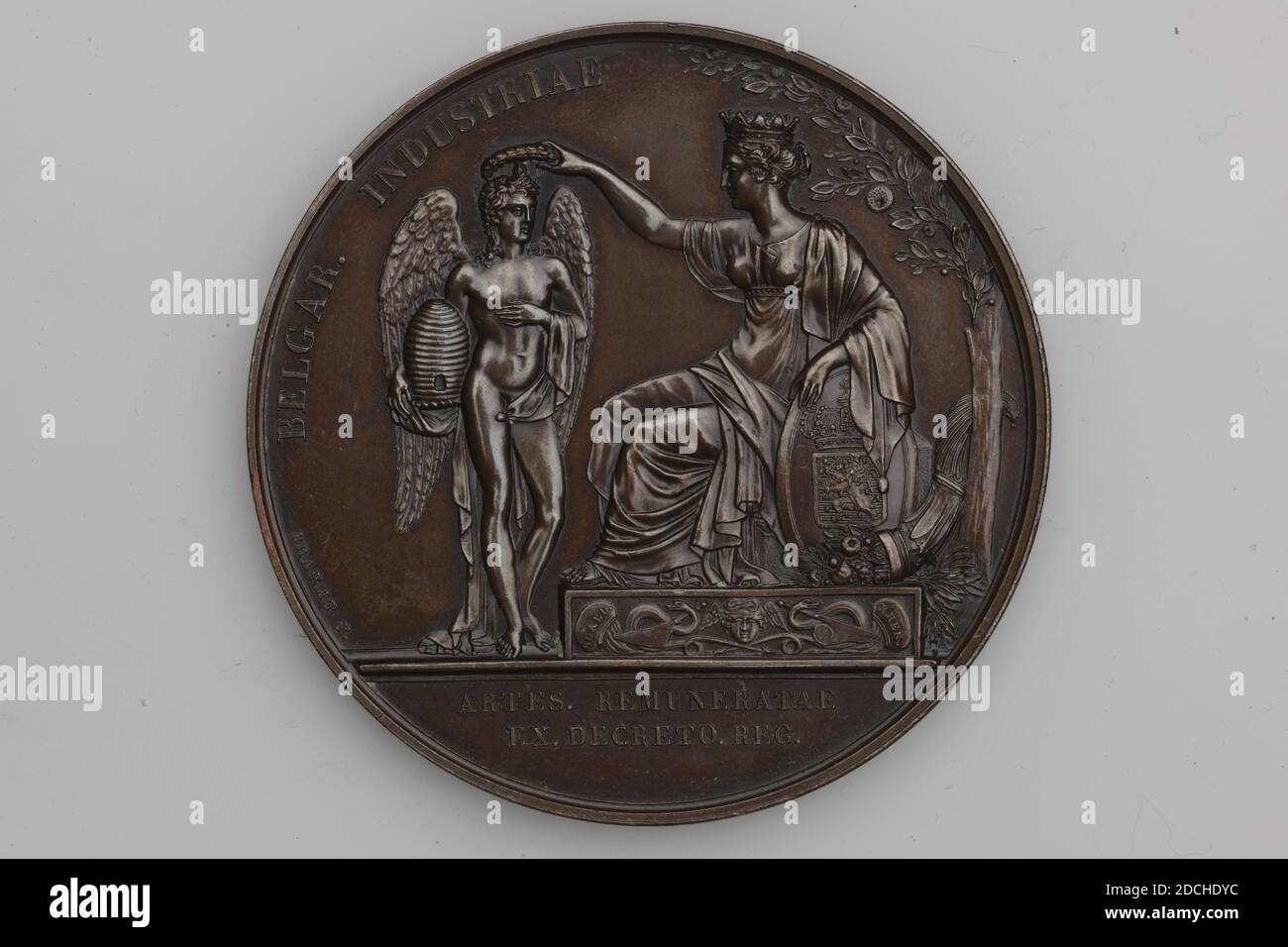 Medaglia di premio, Joseph Pierre Braemt, 1825, coniati, Generale: 5.8 x 0.4cm (58 x 4mm), peso: 92g, personificazione, medaglia di premio d'argento da una mostra industriale belga nel 1825. Impresso sul davanti l'immagine di una donna seduta con una corona sulla testa e il braccio appoggiato su uno scudo. Mette una corona di alloro sulla testa di un angelo in piedi davanti a lei. L'angelo ha un'alveare sul braccio. Sotto l'immagine il testo: ARTES. REMUNERATAE EX. DECRETO. REG. In lettere minuscole al confine: BREAMT P. in una didascalia parziale il testo: BELGAR. INDUSTRIE. Sul retro un bordo floreale con l'iscrizione Foto Stock