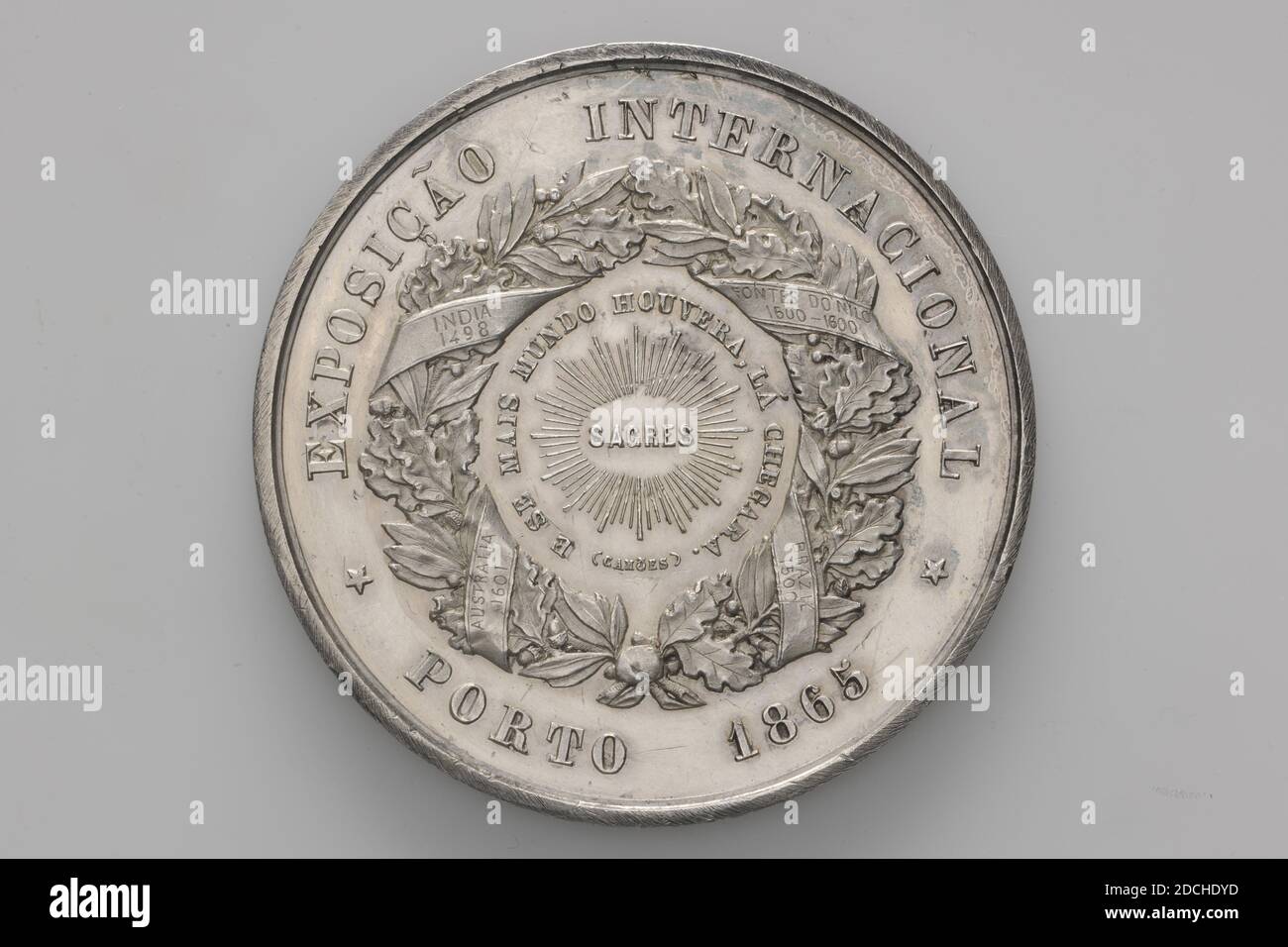 Medaglia di premio, Charles Wiener, 1865, coniata, Generale: 5.8 x 0.4cm (58 x 4mm), peso: 79.2g, allegoria, personificazione, medaglia di premio d'argento all'esposizione Internazionale del 1865 a Porto, vinta dalla società Scheltema . Sul fronte è presente una rappresentazione allegorica con figure che raffigurano l'agricoltura, l'industria, l'arte e la scienza con gli attributi associati. Essi sono raggruppati attorno ad un piedistallo con le braccia di Porto e Portogallo su di esso. A sinistra l'agricoltura con una falce, accanto a industria con un martello e incudine, a destra della base Arte con una tavolozza, e Scienza con un rotolo. Attributi Foto Stock