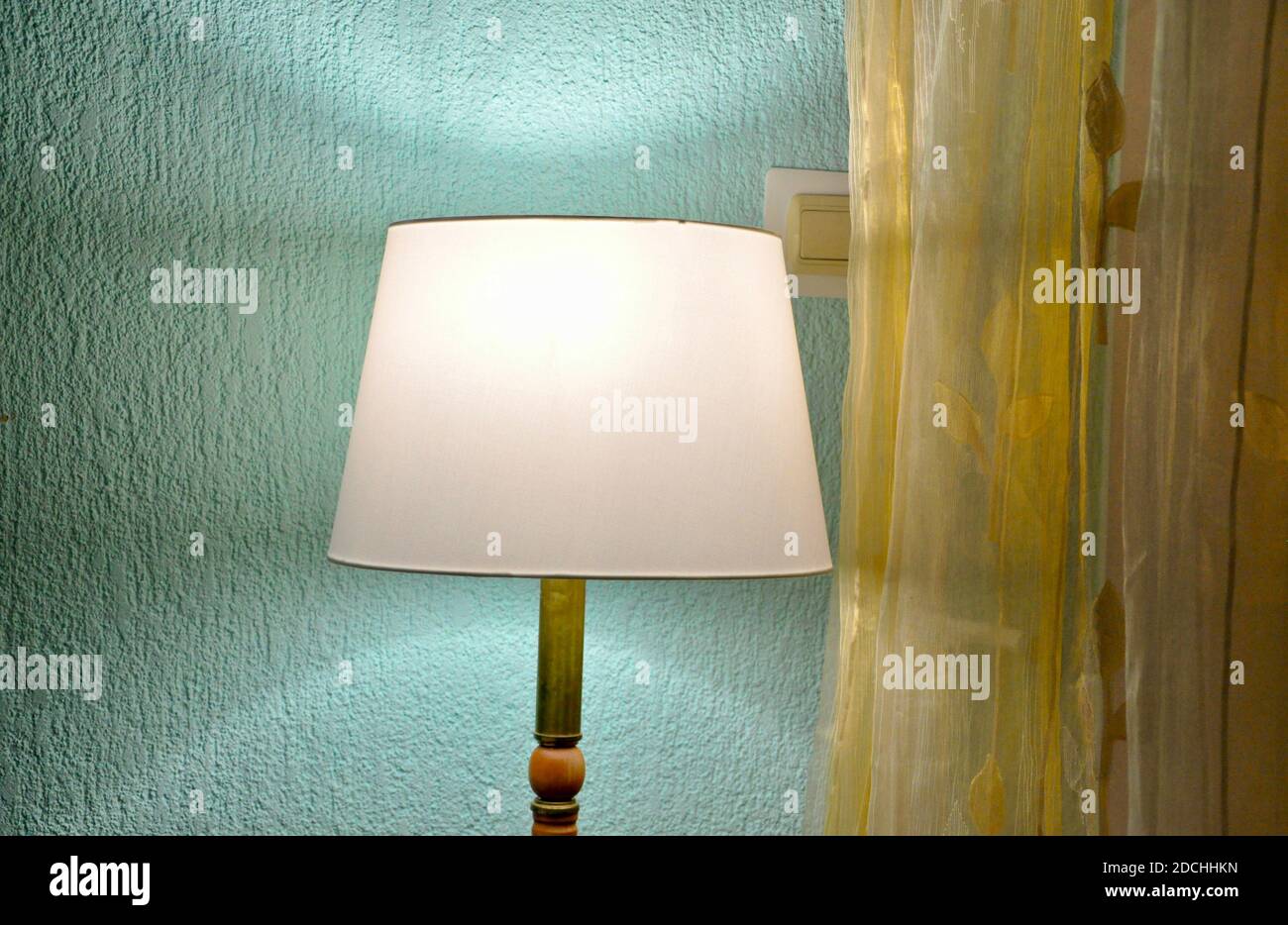 La lampada da pavimento della camera da letto dell'hotel è isolata su sfondo blu tenue. Foto Stock
