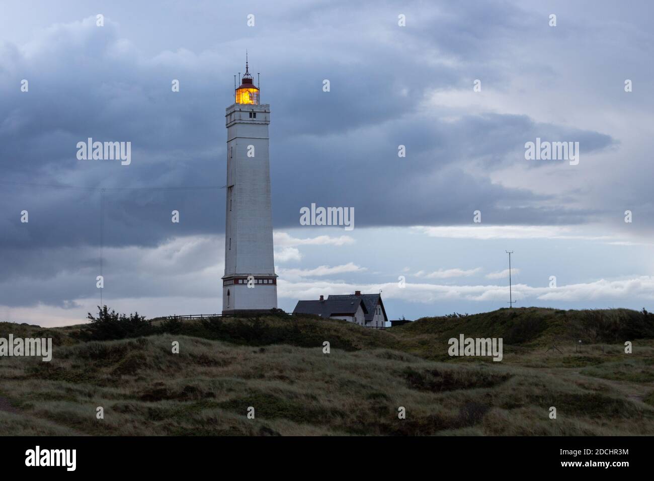 Drammatiche nuvole all'alba al faro di Blavand in Danimarca Foto Stock