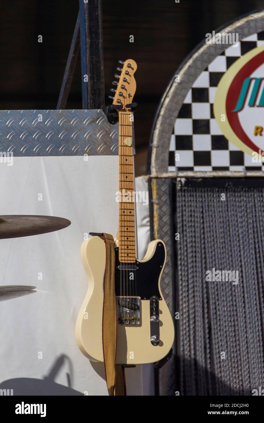 Chitarra elettrica gialla e nera appesa sul palco prima di un concerto Foto Stock