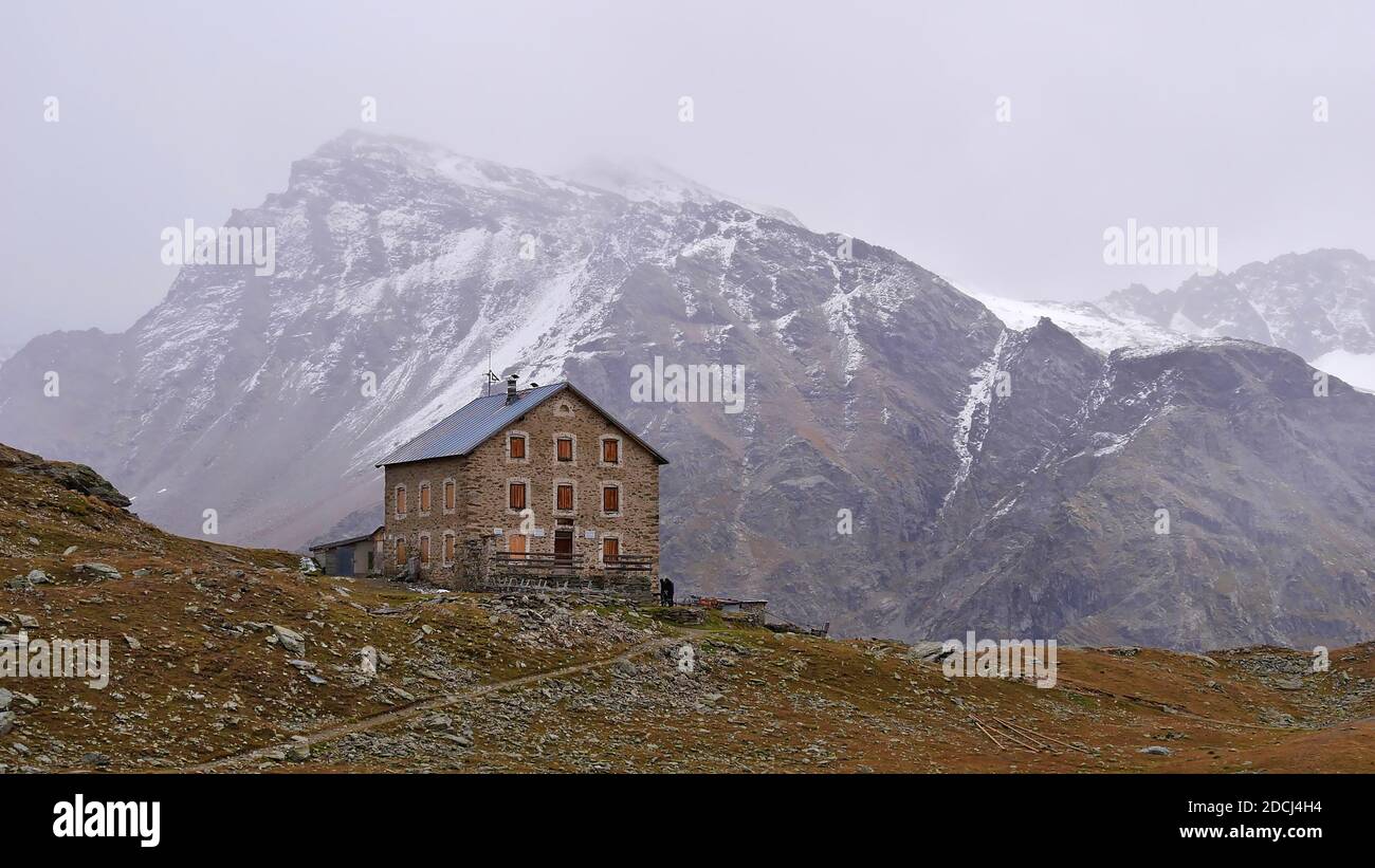 Bella vista del rifugio 'Hintergrathütte' di fronte alle montagne innevate che spariscono nelle nuvole a est del massiccio di Ortler vicino Sulden. Foto Stock