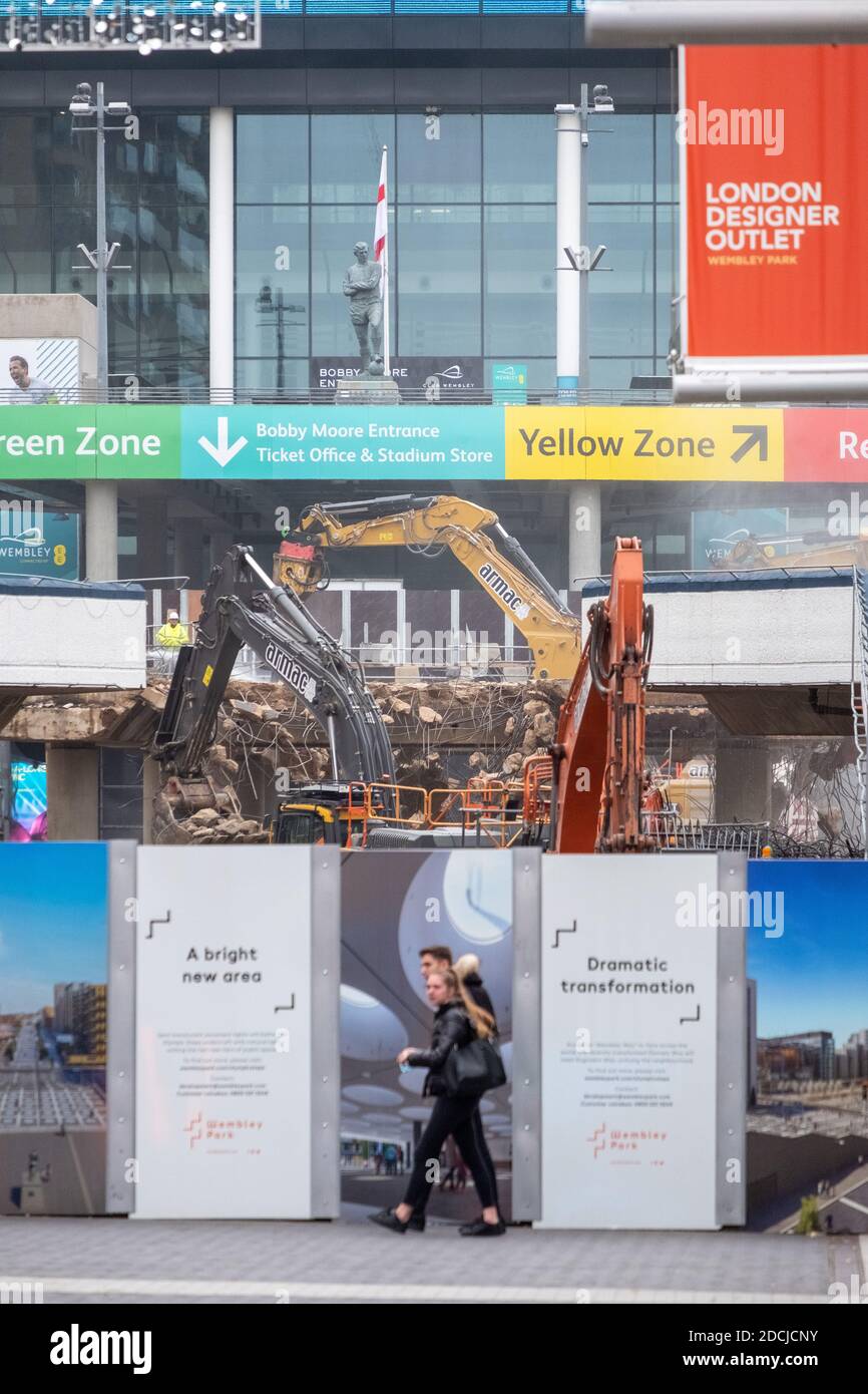 21 novembre 2020. Londra. REGNO UNITO. La statua del calciatore Bobby Moore si affaccia sulla demolizione della famosa rampa pedonale dello stadio di Wembley da parte dei lavoratori edili. L'iconico passaggio di 46 anni fa sta cedendo il passo alla "scalinata olimpica", parte di un piano più ampio per modernizzare la Via Olimpica. Foto di Ray Tang. Foto Stock