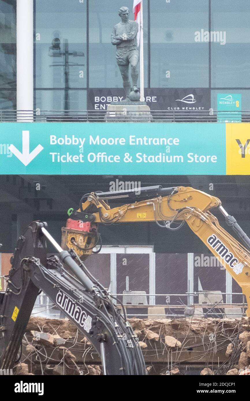 21 novembre 2020. Londra. REGNO UNITO. La statua del calciatore Bobby Moore si affaccia sulla demolizione della famosa rampa pedonale dello stadio di Wembley da parte dei lavoratori edili. L'iconico passaggio di 46 anni fa sta cedendo il passo alla "scalinata olimpica", parte di un piano più ampio per modernizzare la Via Olimpica. Foto di Ray Tang. Foto Stock