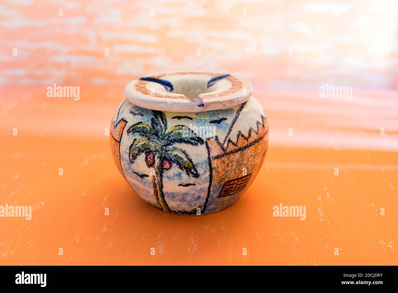 Bella pittura di palma in ceramica fatta a mano Ashtray su sfondo astratto giallo gradiano per decorazione di casa. Foto Stock