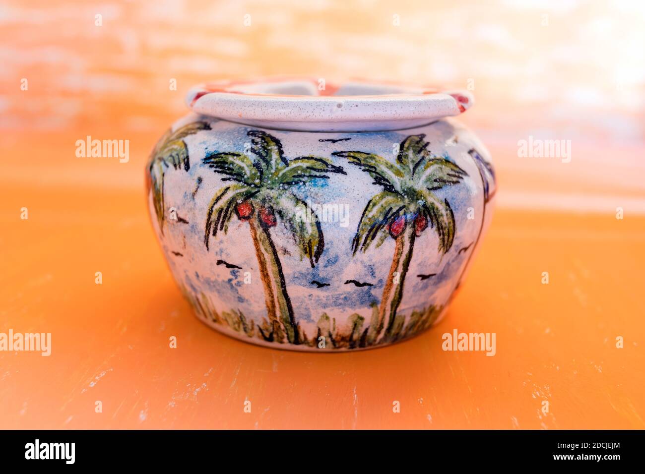 Bella pittura di palma in ceramica fatta a mano Ashtray su sfondo astratto giallo gradiano per decorazione di casa. Foto Stock