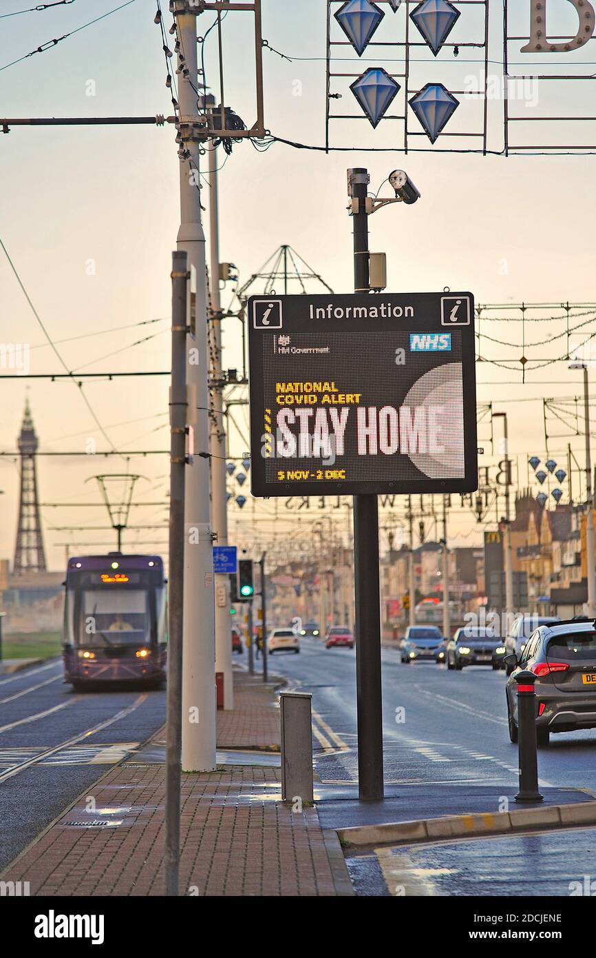 Traffico stradale che passa National Covid Alert segnale elettronico tra principale strada e tram Foto Stock