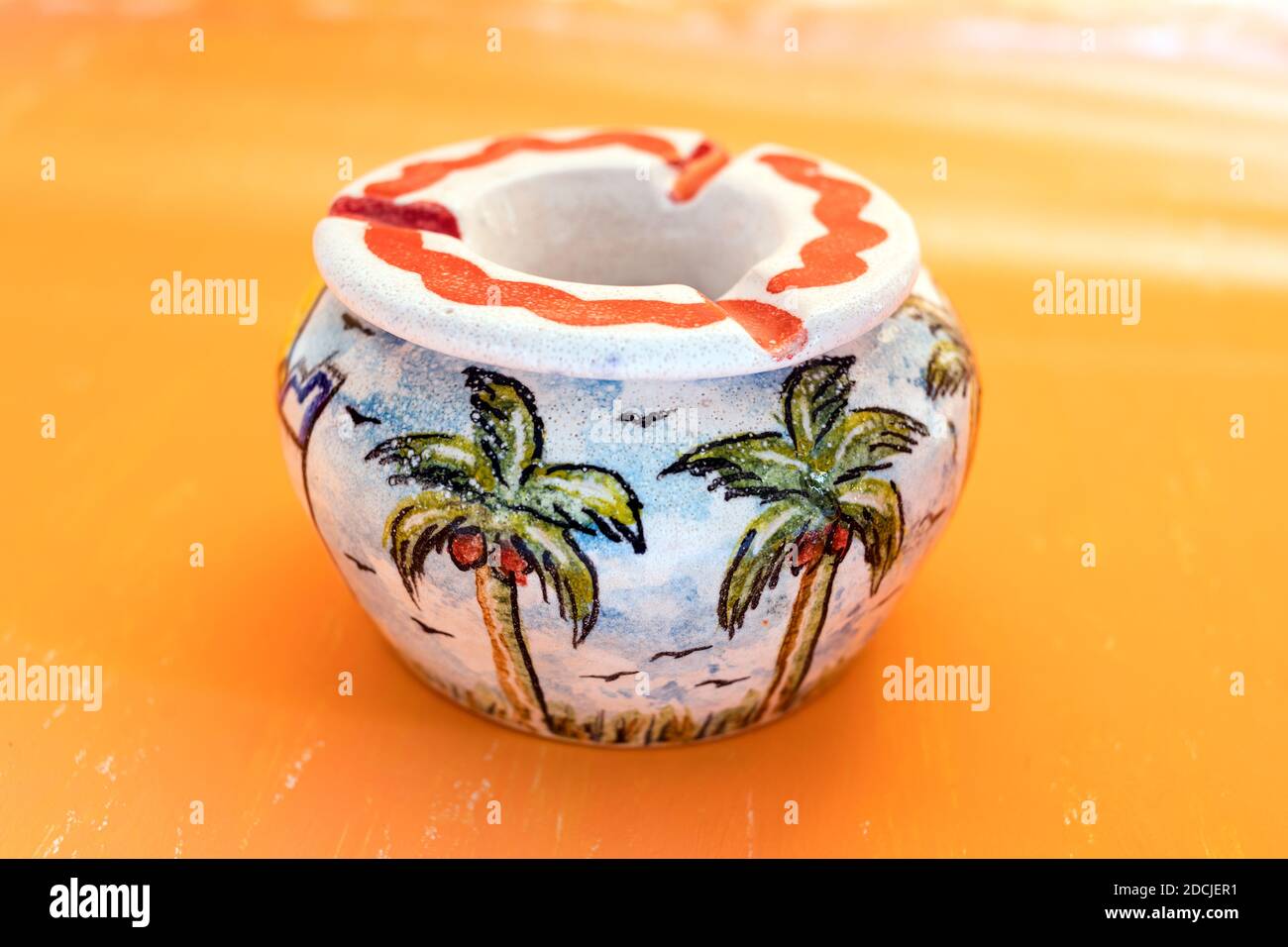 Bella pittura di palma in ceramica fatta a mano Ashtray su sfondo astratto giallo gradiano per decorazione di casa. Foto Stock