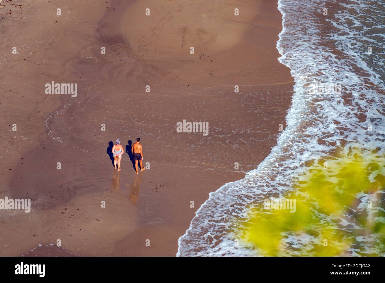 Due figure sulla spiaggia presso la popolare destinazione di vacanza e luogo di sole invernale di Benidorm, Costa Blanca, Spagna, spiagge spettacolari Foto Stock