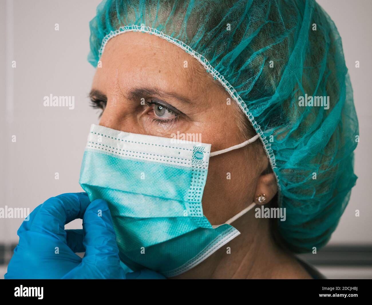 Ritratto professionista sanitario donna con protezione contro covid 19 mettere la sua maschera Foto Stock