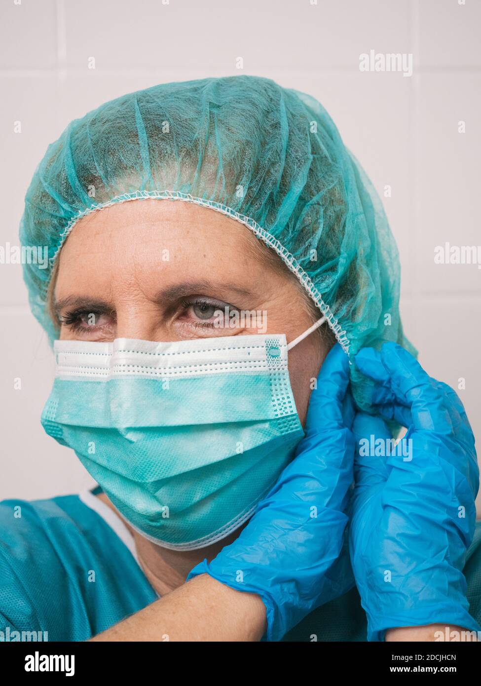 Ritratto professionista sanitario donna con protezione contro covid 19 mettere la sua maschera Foto Stock