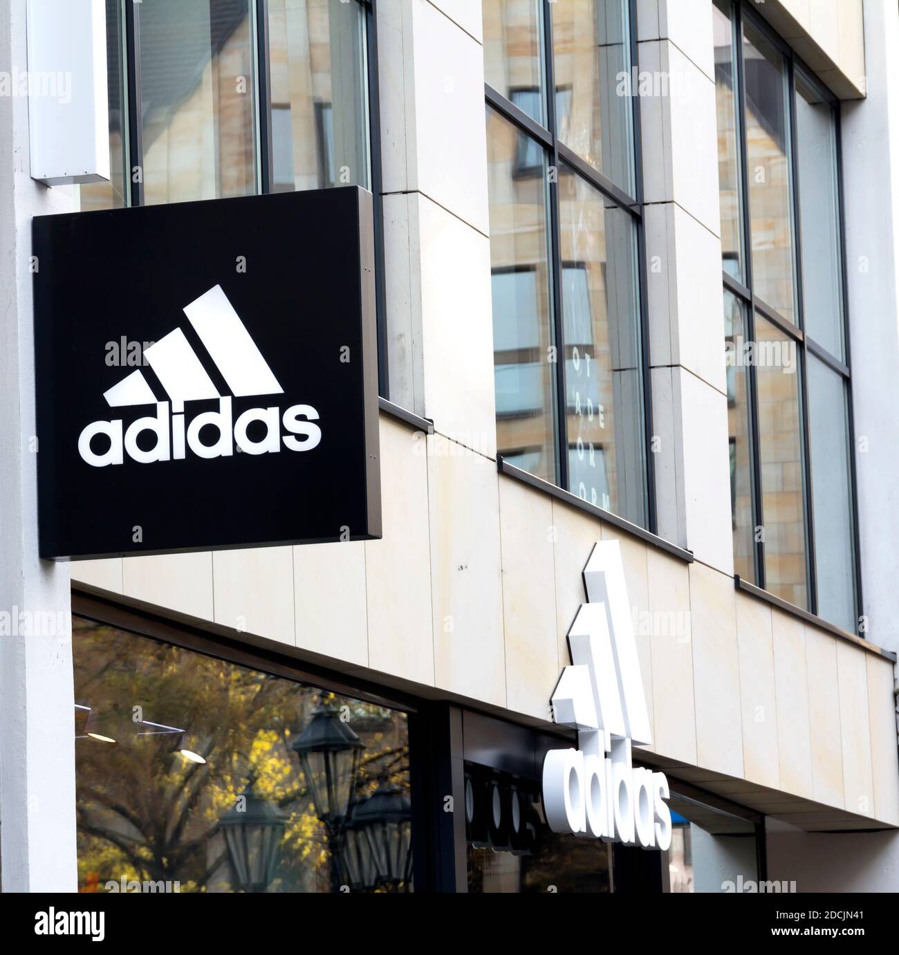 Logo Adidas su una parete. Adidas è una multinazionale tedesca che produce  scarpe sportive, abbigliamento Foto stock - Alamy