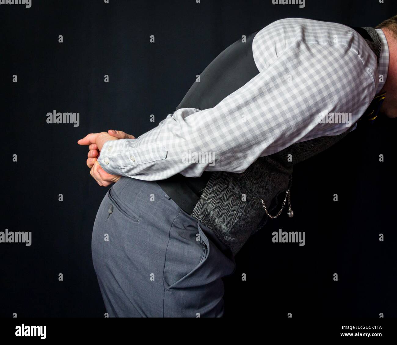 Ritratto di uomo in Tweed gilet tenendo le mani dietro la schiena e inchinandosi. Cortesia e gentilezza Umile e deferenziale. Foto Stock