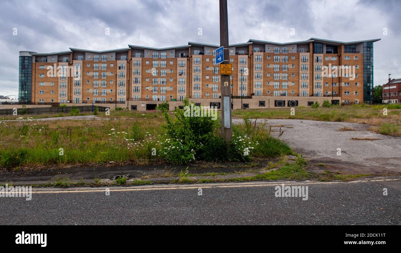 Salford, Inghilterra, Regno Unito - 16 giugno 2012: Edifici di appartamenti di nuova costruzione si trovano accanto al terreno di spreco durante la rigenerazione del quartiere Middlewood Locks Foto Stock