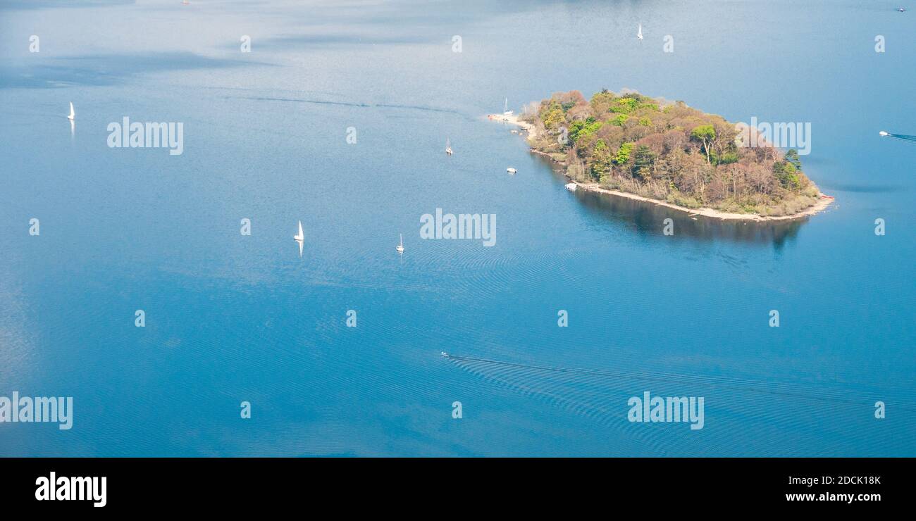 Le barche navigano intorno alla piccola isola boscosa di St Herbert nel lago d'acqua di Derwent, visto dalla montagna Catbells nel Distretto dei Laghi d'Inghilterra. Foto Stock