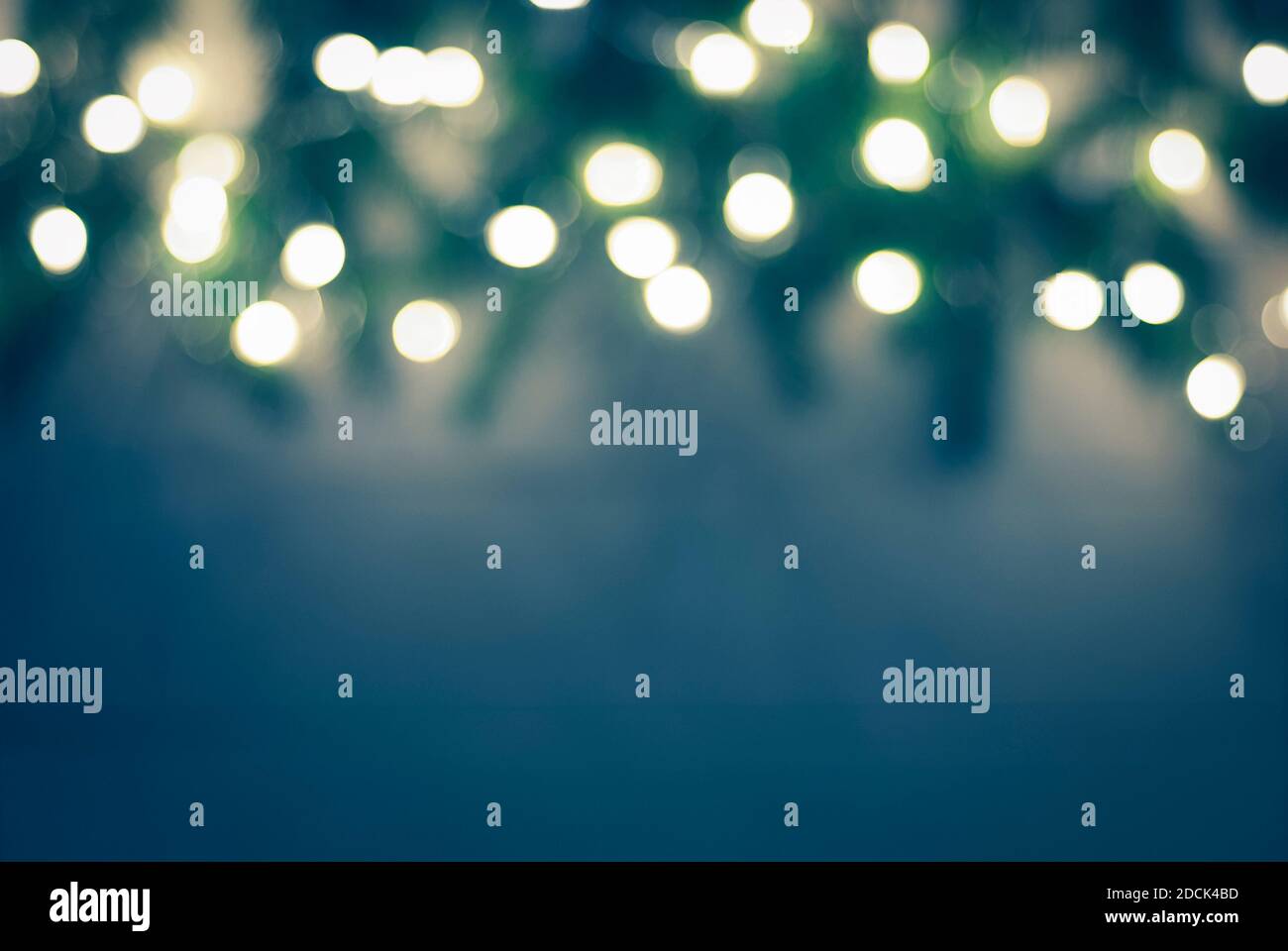 blu scuro verde scuro sfondo di natale sfocato con le luci bokeh garland e bordi di ramoscelli di abete rosso sfocato Foto Stock