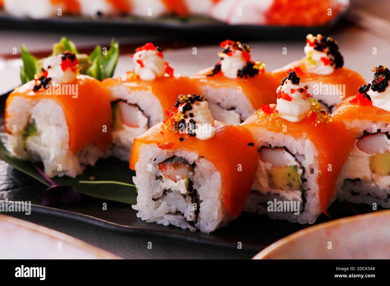 primo piano di panini di sushi con avocado, granchio, salmone, uova multicolore e salsa di soia Foto Stock