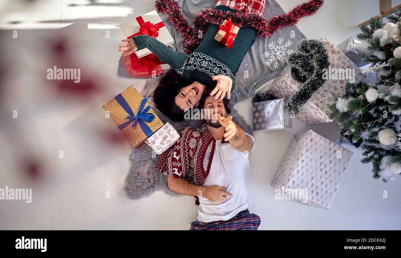 Una bella coppia ha divertimento in posa per una foto di Natale su una bella mattina di vacanza a casa. Natale, rapporto, amore, insieme Foto Stock