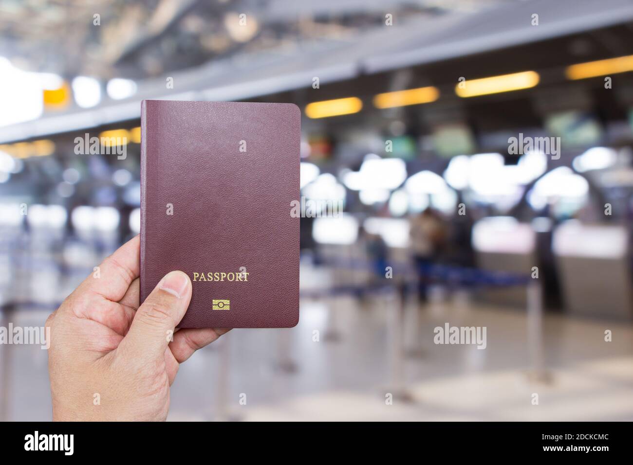 Mano di un uomo con passaporto internazionale in attesa davanti al banco per il check-in all'aeroporto Suvarnabhumi di Samutprakan. Thailandia. Foto Stock