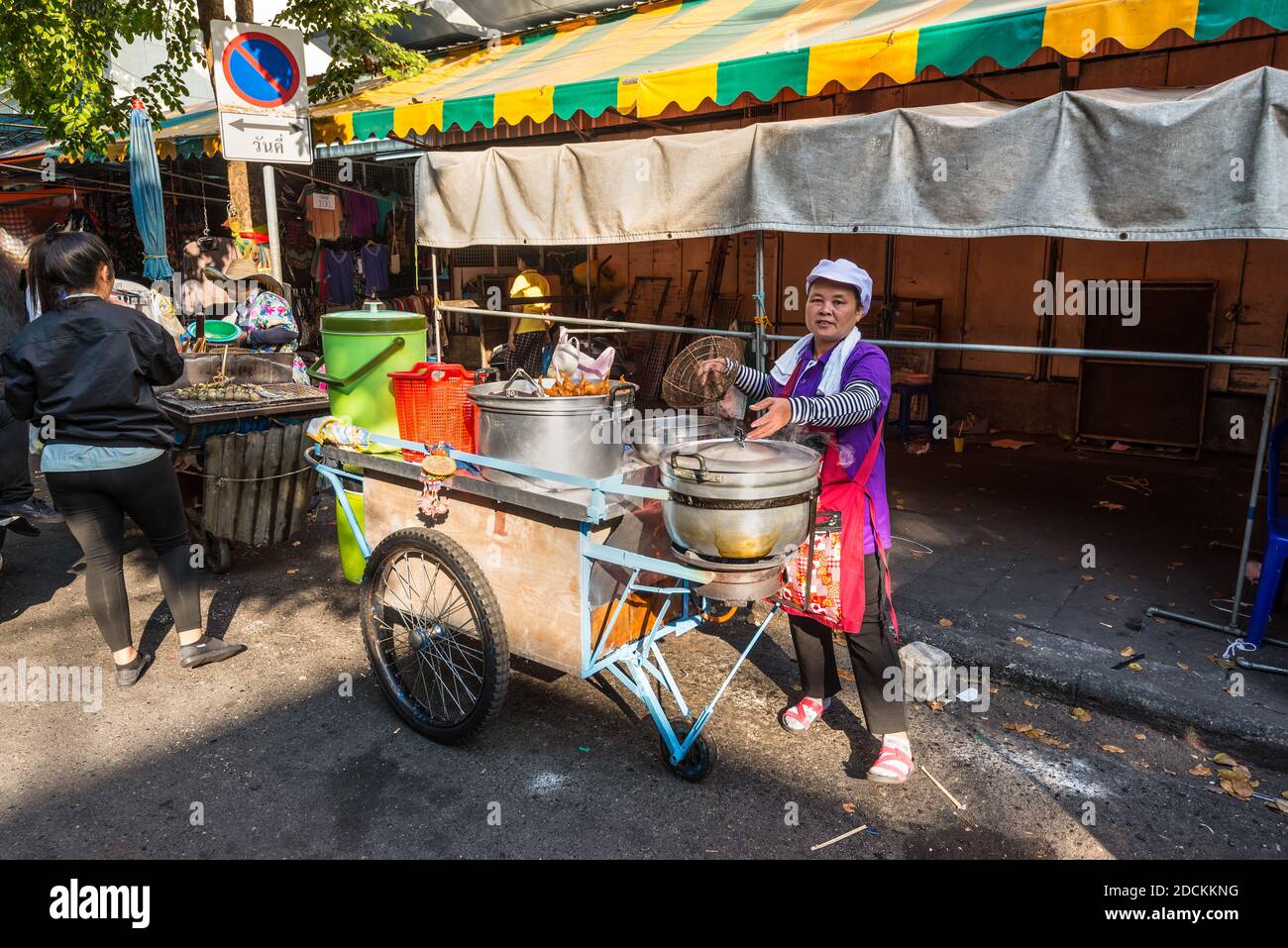 Bangkok, Thailandia - 7 dicembre 2019: Donna locale con il suo carrello che vende cibo caldo per le strade di Bangkok, Thailandia. Foto Stock