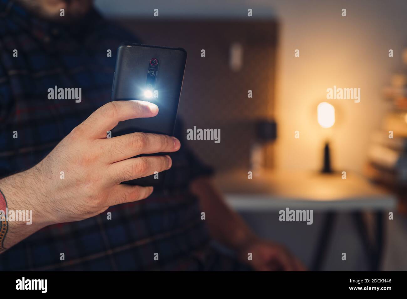 Un primo piano della mano di un uomo che scatta una foto con una torcia con  fotocamera del telefono cellulare accesa Foto stock - Alamy