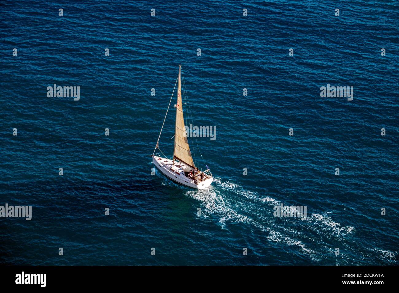 Piccolo yacht che naviga verso la popolare destinazione di vacanza e luogo di sole invernale di Benidorm, Costa Blanca, Spagna, visto dalla collina di Tossal de la Cala Foto Stock