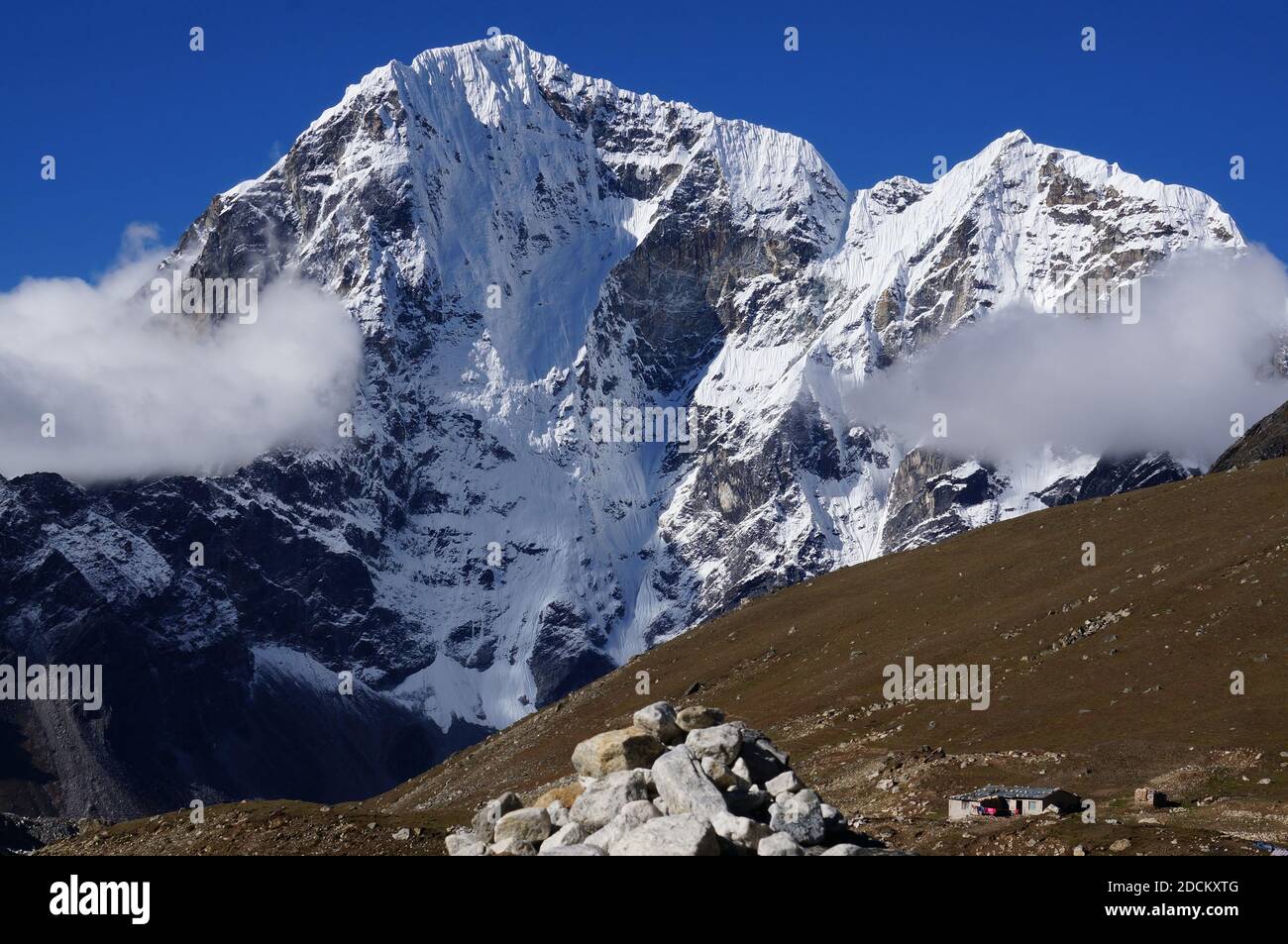 La cima delle montagne innevate dell'Himalaya sopra le nuvole. Nepal. Foto Stock