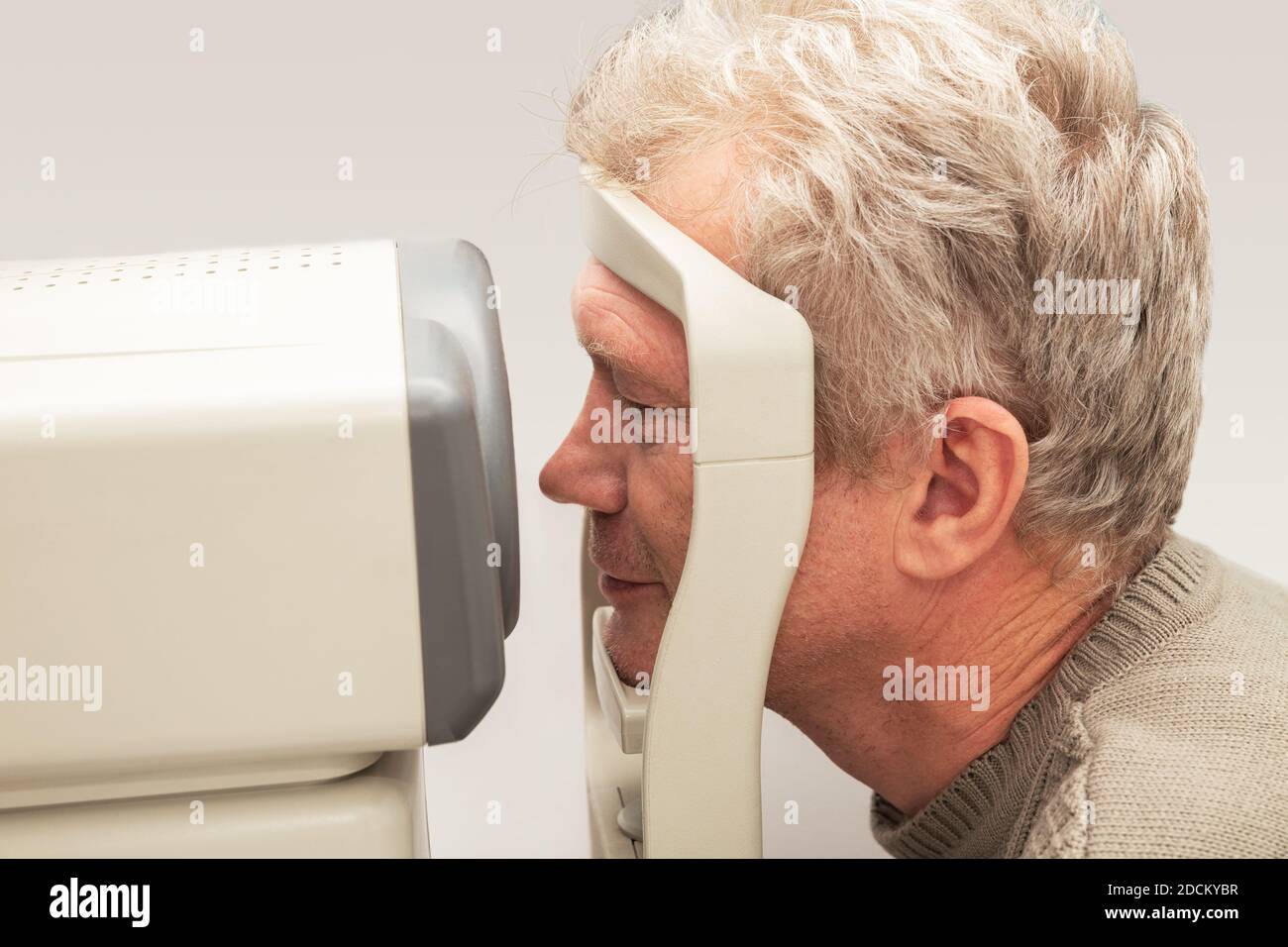 L'uomo controlla la sua vista su attrezzature mediche moderne in un clinica oftalmologica Foto Stock
