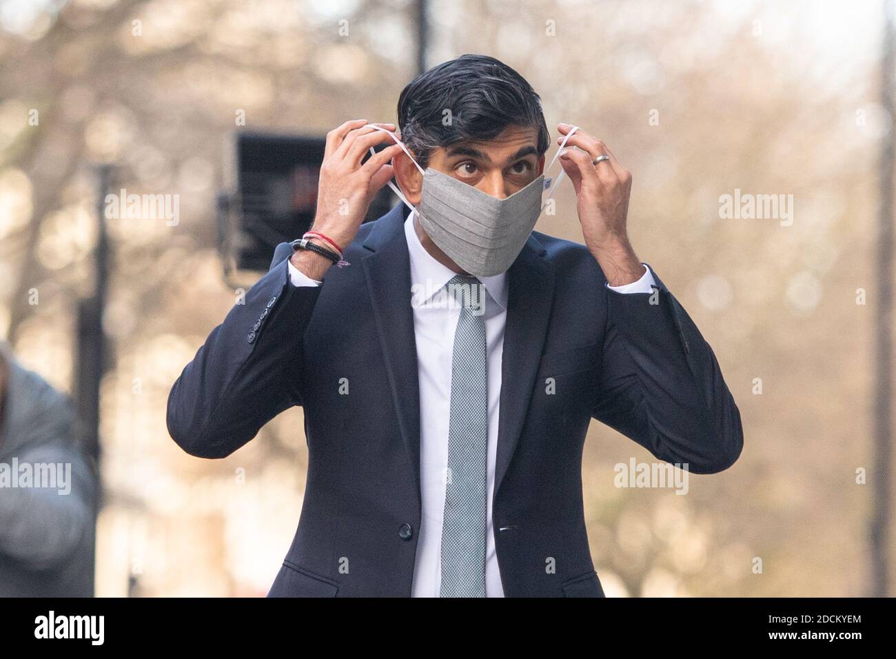 Il Cancelliere dello scacchiere Rishi Sunak si mette su una maschera dopo essere stato intervistato via video per Sophy Ridge di Sky News domenica, al di fuori della BBC Broadcasting House nel centro di Londra. Foto Stock