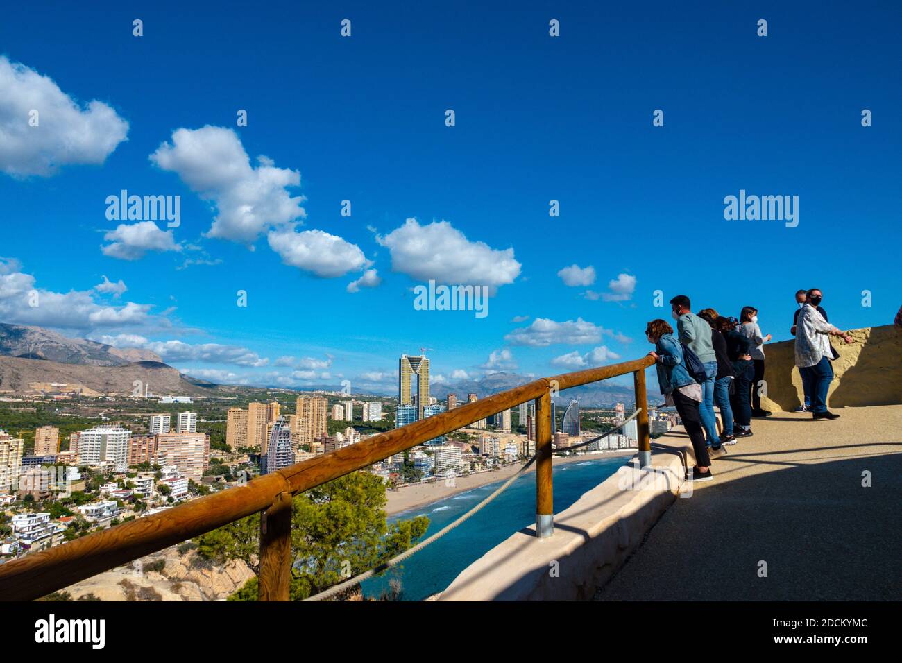 I turisti che guardano sulla popolare destinazione di vacanza e luogo di sole invernale di Benidorm, Costa Blanca, Spagna, visto dalla collina di Tossal de la Cala Foto Stock