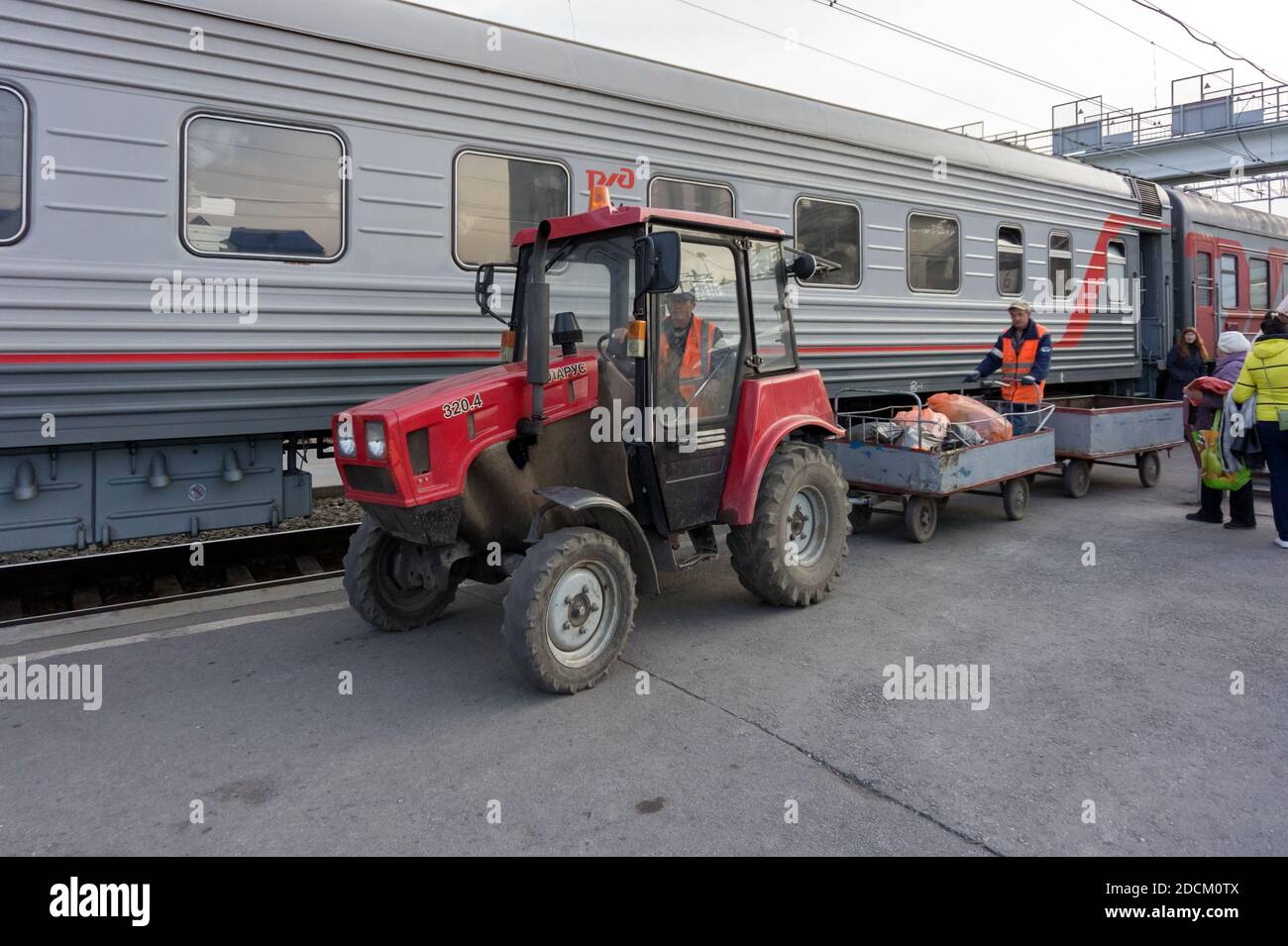 Il trattore rimuove i rifiuti da un treno che si trova sulla piattaforma Della città Siberiana Barabinsk stazione ferroviaria Foto Stock