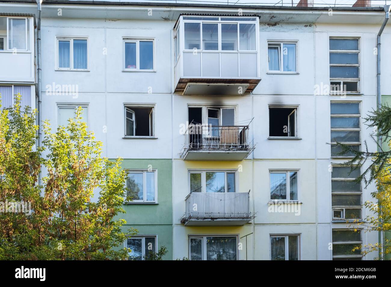 Incendio in un edificio residenziale. Finestre aperte e rotte di un appartamento bruciato, fuliggine sulla facciata dell'edificio. Foto Stock