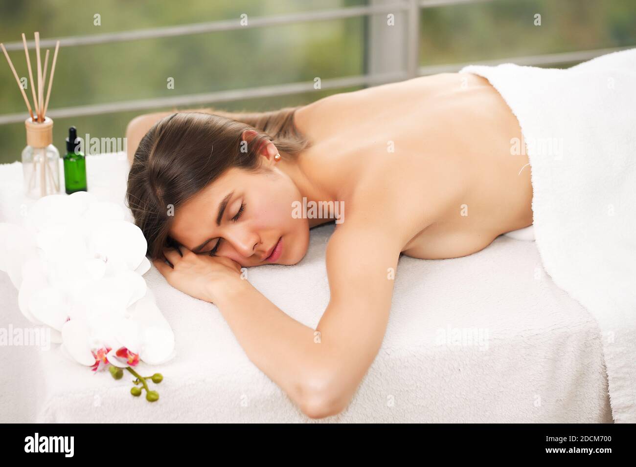 Giovane bruna caucasica decide di iniziare la sua giornata con un massaggio rilassante in clinica benessere. Stile di vita sano e Spa Foto Stock