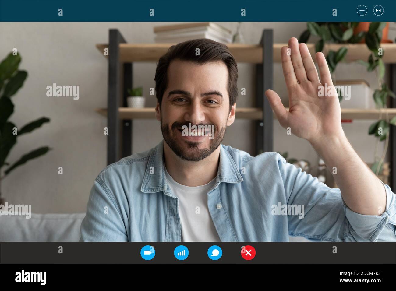 Sorridente giovane bell'uomo guardando la web camera, salutando gli amici. Foto Stock
