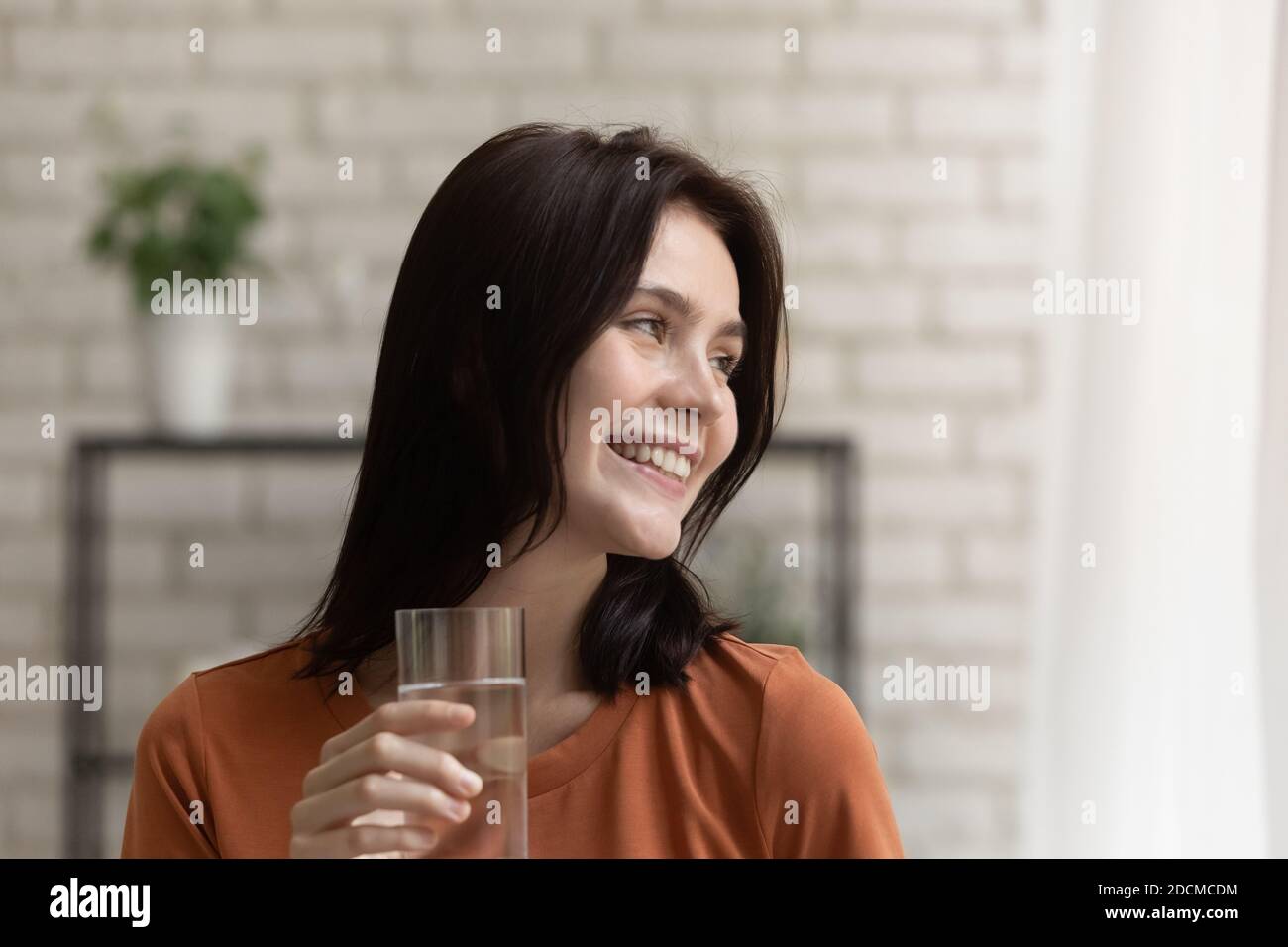 Felice millennial attraente donna sentendosi rinfrescato, acqua potabile. Foto Stock