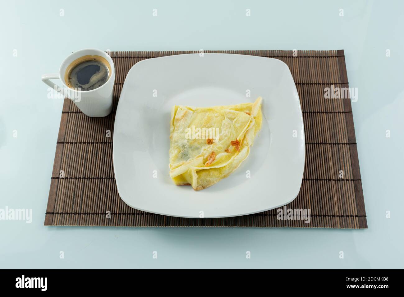 Crepioca con ripieno di formaggio caldo accanto ad una tazza di caffè (ricetta brasiliana con tapioca e uovo). Foto Stock