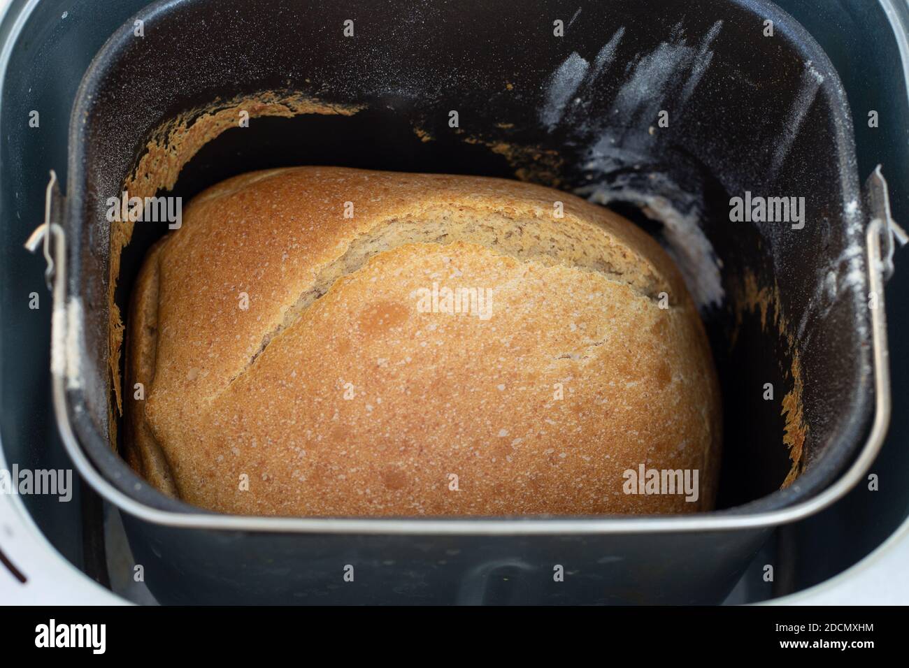 cuocere il pane bianco a casa, cuocere il pane fresco fragrante in una macchina per il pane. Foto Stock