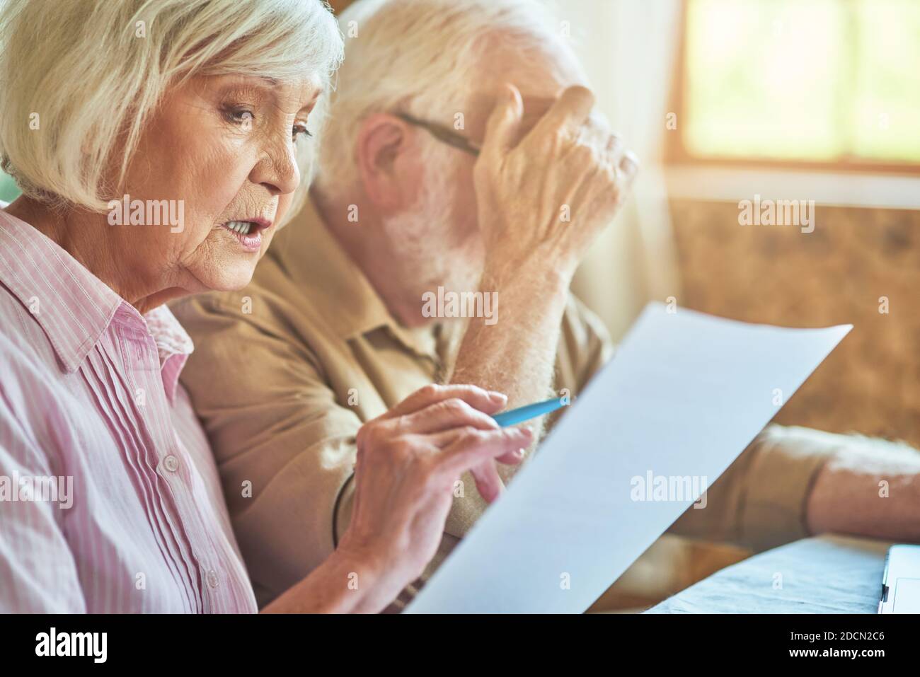 Primo piano di coppie anziane sposate seduti al tavolo a casa loro mentre la gestione del loro budget. Concetto di famiglia e di famiglia Foto Stock