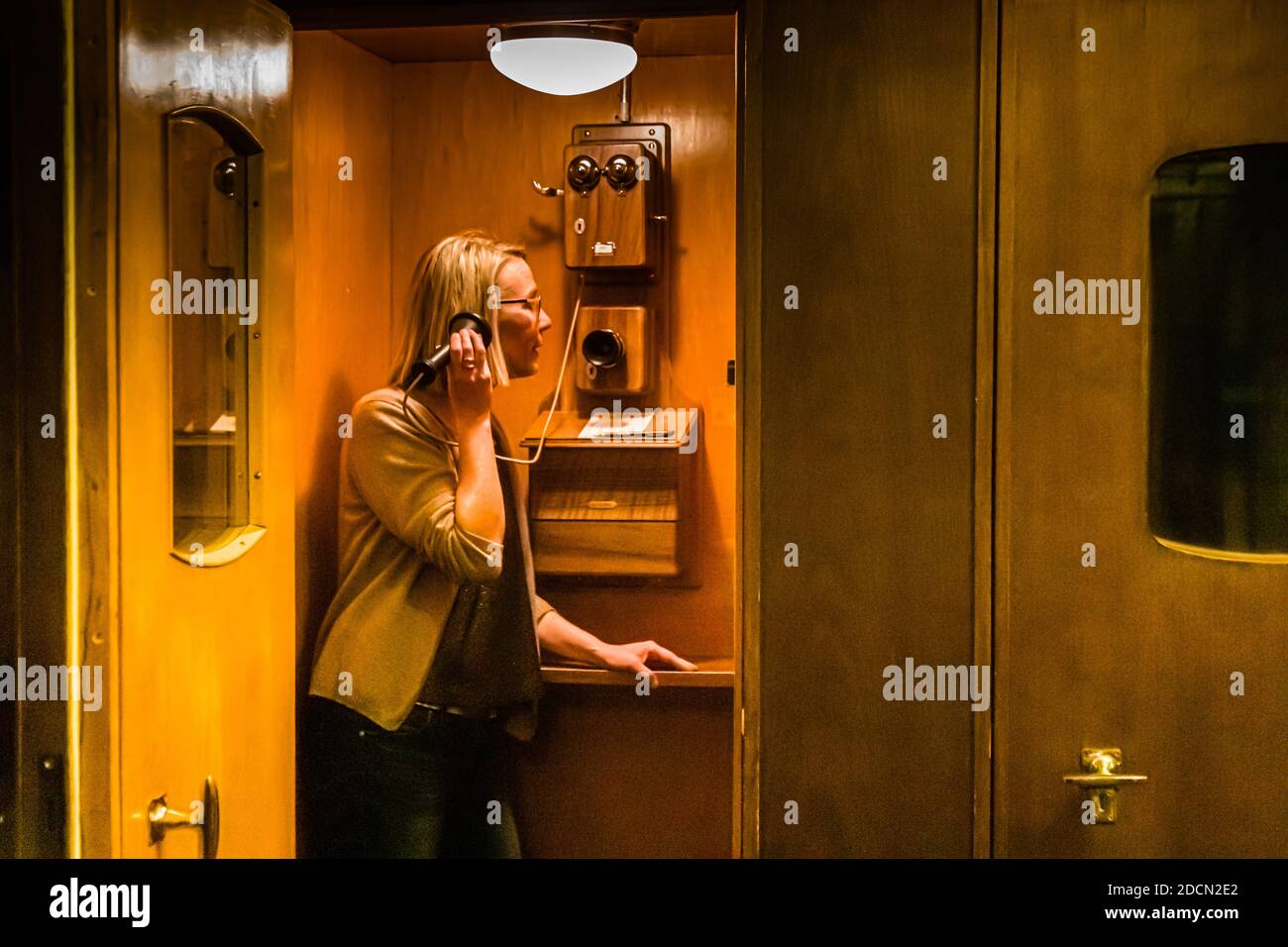 Vecchia cabina telefonica con telefono a parete presso l'Hotel Waldhaus, Sils im Engadin, Svizzera. La vecchia cabina telefonica nel Waldhaus è ora un ritiro cellulare a beneficio di tutti gli ospiti che vogliono utilizzare le sale e molti altri posti della casa per leggere, giocare, parlare o pensare. Momenti piacevoli quando il telefono si trovava nella propria cabina e non in tasca a tutti Foto Stock