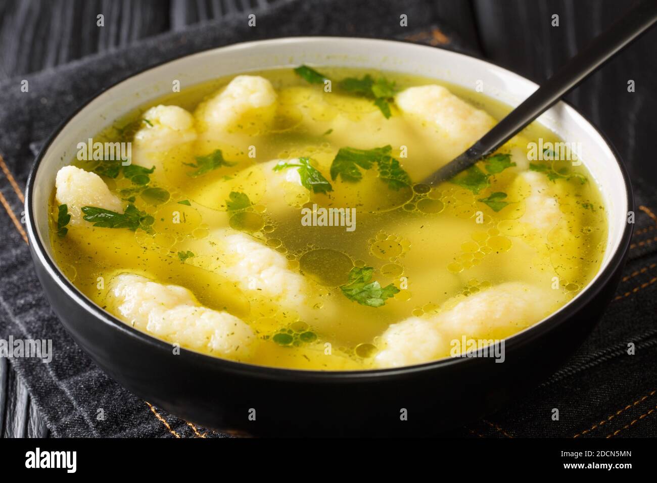 Griessnockerlsuppe manzo e semola Dumpling zuppa primo piano in un piatto sul tavolo. Orizzontale Foto Stock