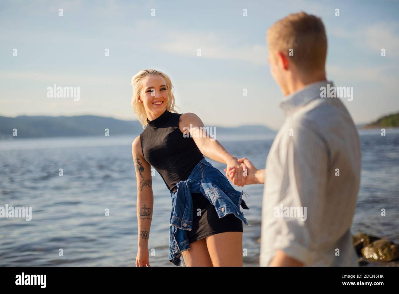 Donna sorridente guardando il ragazzo tenendo mano Foto Stock