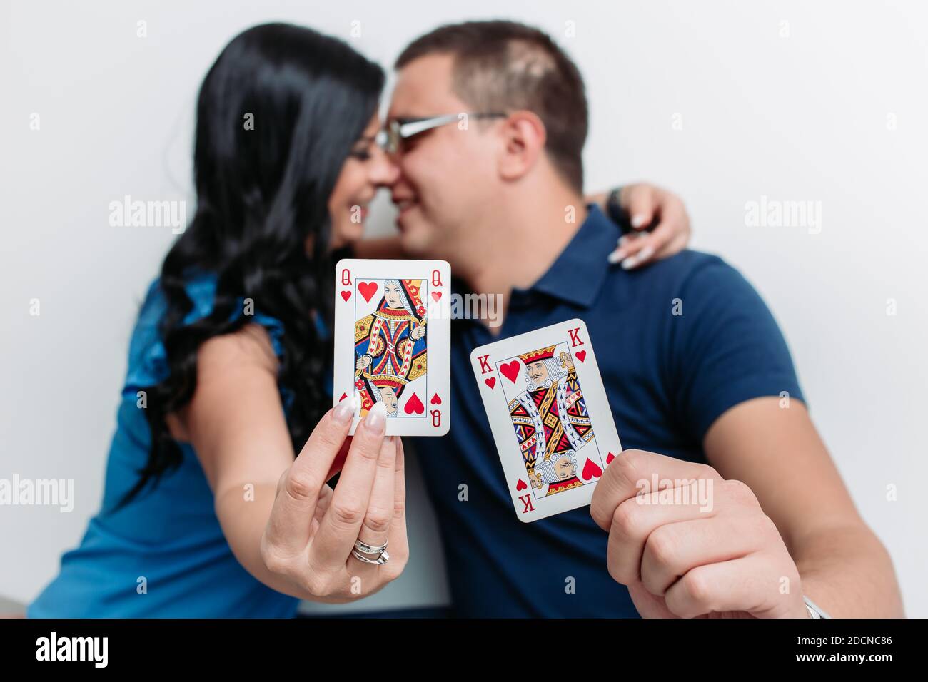 Giovane coppia baciandosi mentre tiene la regina rossa e il re che gioca scheda Foto Stock