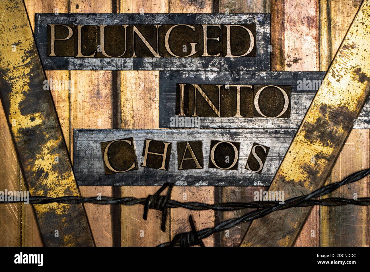 Immerso nel messaggio di testo Chaos su rame grunge vintage testurizzato e sfondo in bronzo con filo spinato Foto Stock