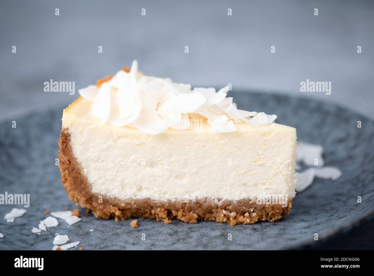 Fetta di torta di cocco vegana su un piatto. Cheesecake di anacardi di cocco Foto Stock