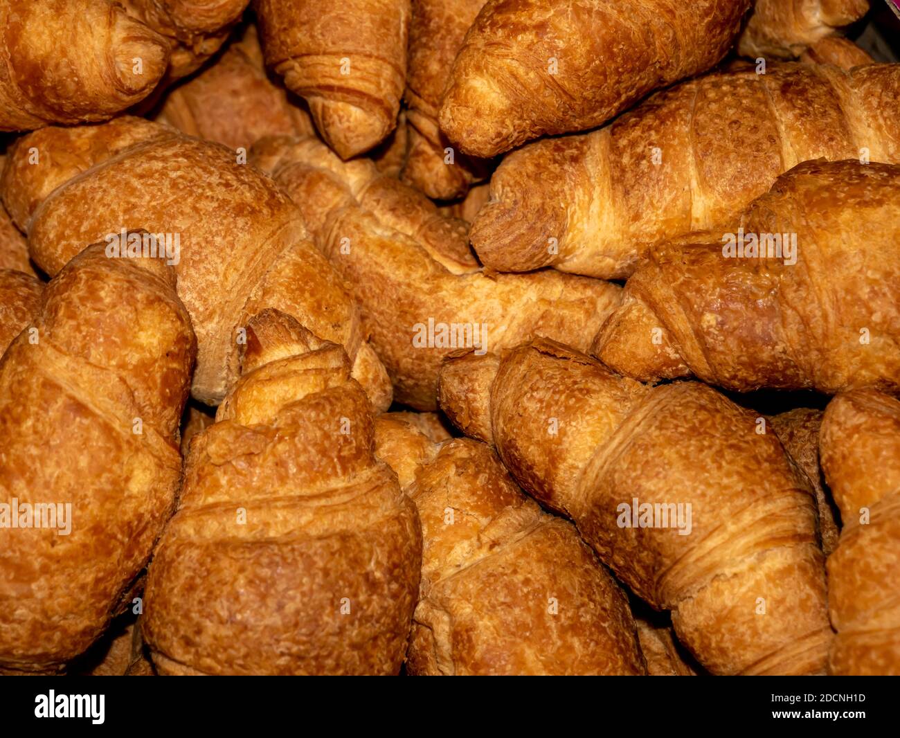 Deliziosi croissant gialli croccanti con ripieno giacciono in un mucchio Foto Stock