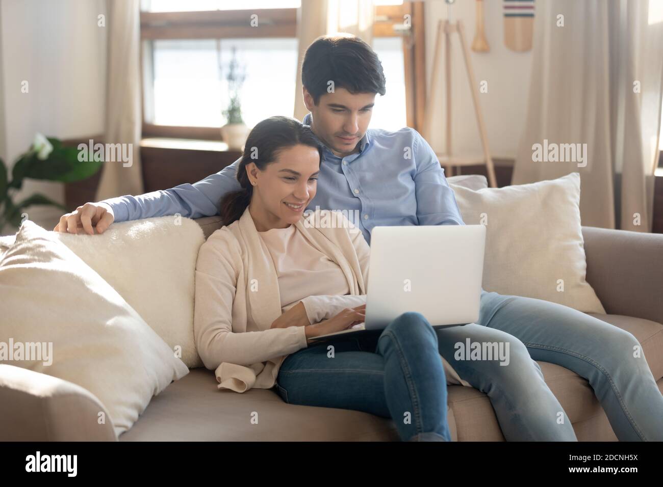 Bonding coppia in amore avendo data a casa utilizzando il laptop Foto Stock